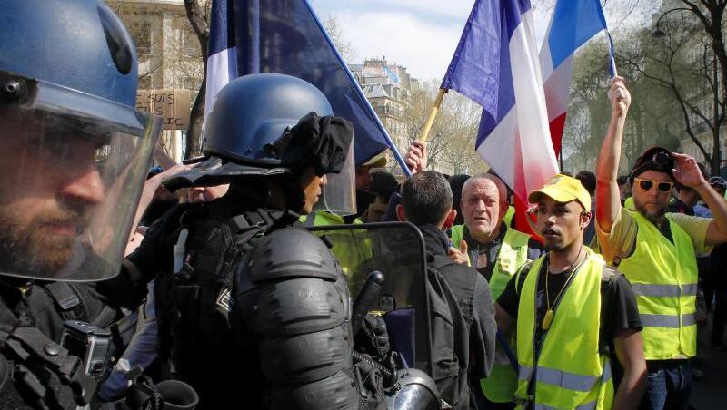 Polizisten vor Demonstranten und Anhängern der "Gelbwesten"-Bewegung, die an einer Protestkundgebung in Paris teilnehmen. Polizisten vor Demonstranten und Anhängern der "Gelbwesten"-Bewegung, die an einer Protestkundgebung in Paris teilnehmen.