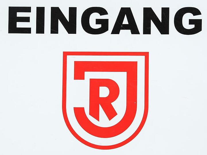 "Eingang" steht über dem Logo des SSV Jahn Regensburg. Foto: Armin Weigel/dpa/Archivbild