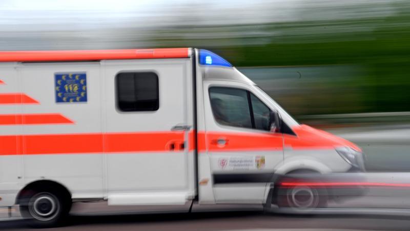 Ein Krankenwagen fährt mit Blaulicht auf einer Straße.