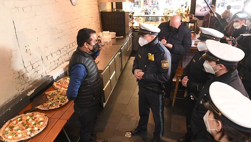 Polizisten bei einem Kontrollgang durch Lokale im Tal im Gespräch mit Pizzeria-Betreiber Radhey Parkash.