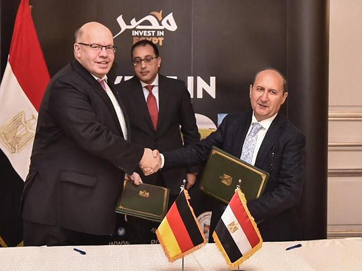 Bundeswirtschaftsminister Peter Altmaier (l) tauscht in Kairo Dokumente mit Amr Nassar, Ägyptens Minister für Industrie, Handel und Handwerk. Im Hintergrund steht Ministerpräsident Mustafa Madbouly.