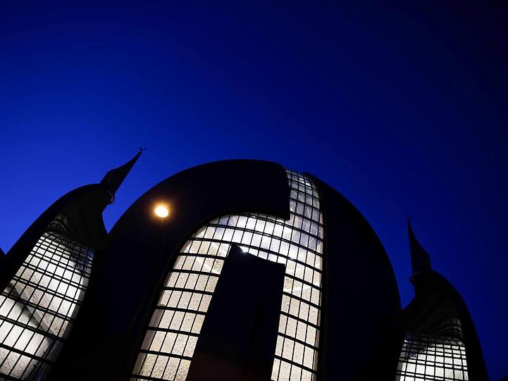 Die Zentralmoschee der DITIB leuchtet im Abendlicht. Foto: Rolf Vennenbernd/dpa/Archivbild