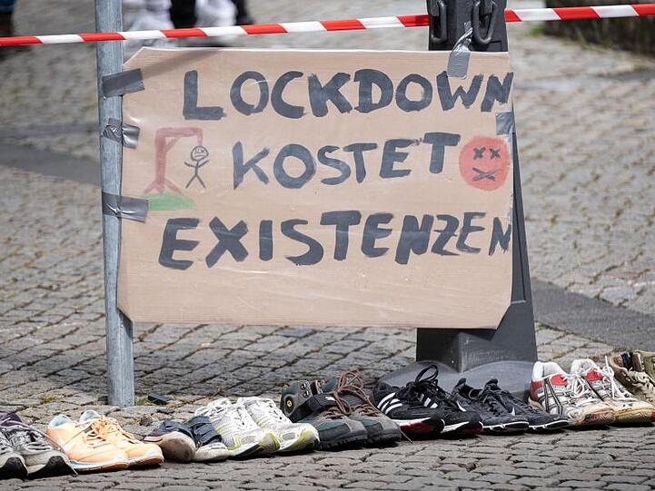 Ein Plakat mit der Aufschrift "Lockdown kostet Existenzen". Foto: Peter Steffen/dpa/Archivbild