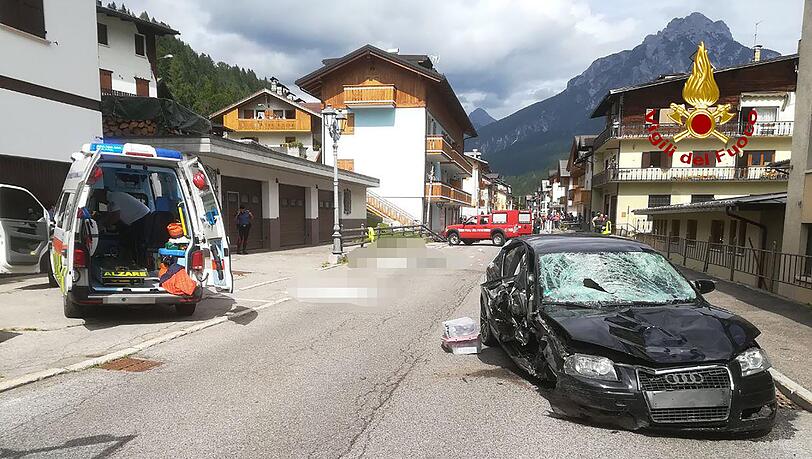 Ein Krankenwagen und das Auto der Deutschen stehen nach dem Unfall auf der Straße.