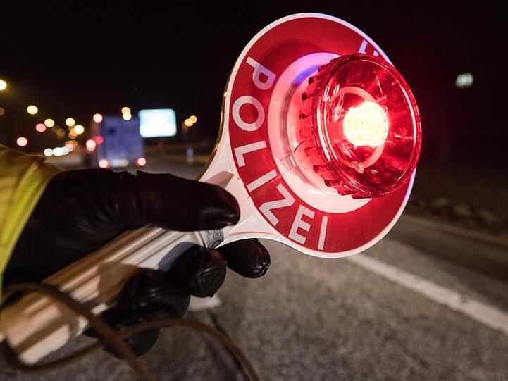 Ein Polizist hält während einer Verkehrskontrolle eine Polizeikelle. Foto: Patrick Seeger/Archiv