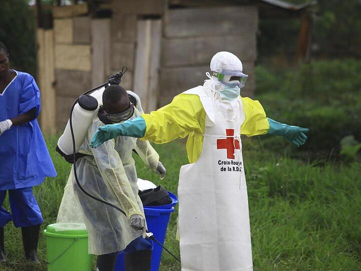Helfer reinigen sich nach der Arbeit in einem Behandlungszentrum gegen Ebola mit Desinfektionsmittel.