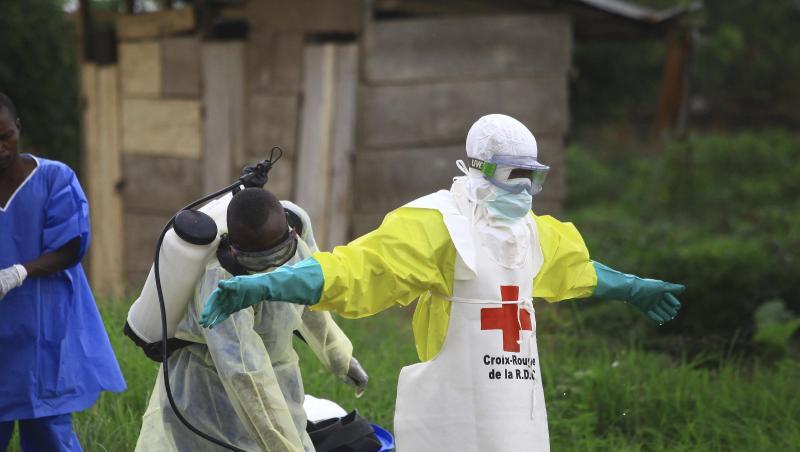 Helfer reinigen sich nach der Arbeit in einem Behandlungszentrum gegen Ebola mit Desinfektionsmittel. Helfer reinigen sich nach der Arbeit in einem Behandlungszentrum gegen Ebola mit Desinfektionsmittel.