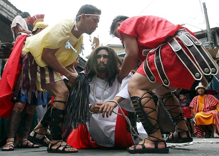 Die Glübigen spielen die Kreuzigung Christi nach.