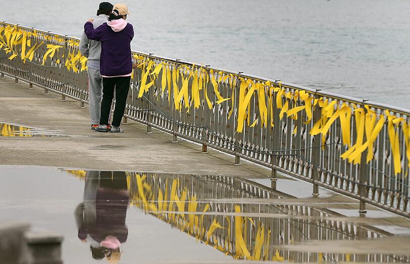 Eine Familie von Opfern der gesunkenen Fähre vor Südkoreas Küste stehen am Paengmok Hafen von Jindo Island. Die gelben Bändchen symbolisieren die Hoffnung auf Rückkehr der Passagiere.