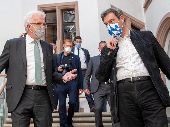 Winfried Kretschmann (Bündnis 90/Die Grünen, l) und Markus Söder (CSU) unterhalten sich. Foto: Stefan Puchner/dpa/Archivbild