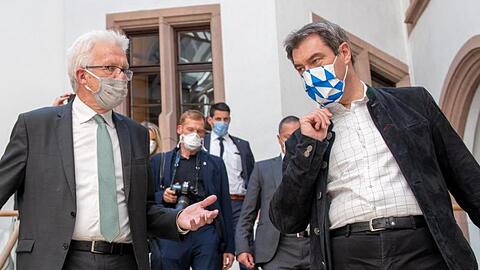 Winfried Kretschmann (Bündnis 90/Die Grünen, l) und Markus Söder (CSU) unterhalten sich. Foto: Stefan Puchner/dpa/Archivbild