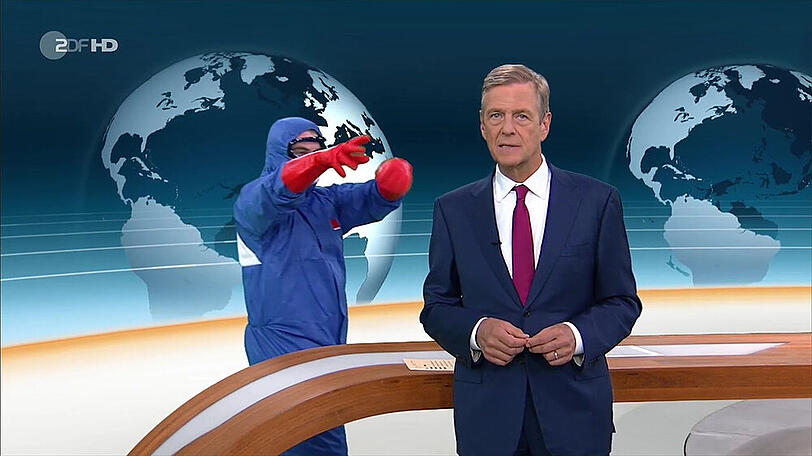 Claus Kleber mit dem vermummten Mann im blauen Ganzkörperschutzanzug im Hintergrund.