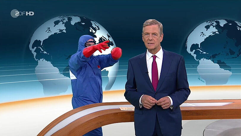 Claus Kleber mit dem vermummten Mann im blauen Ganzkörperschutzanzug im Hintergrund. Claus Kleber mit dem vermummten Mann im blauen Ganzkörperschutzanzug im Hintergrund.