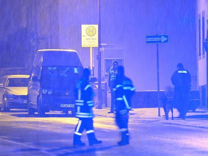 Ein Polizist mit Suchhund geht zu dem Mehrfamilienhaus, in dessen Keller rund 50 Kilogramm Sprengstoff gefunden wurde.
