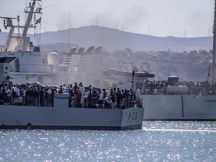 Migranten werden mit Schiffen der italienischen Marine von Lampedusa nach Sizilien gebracht.