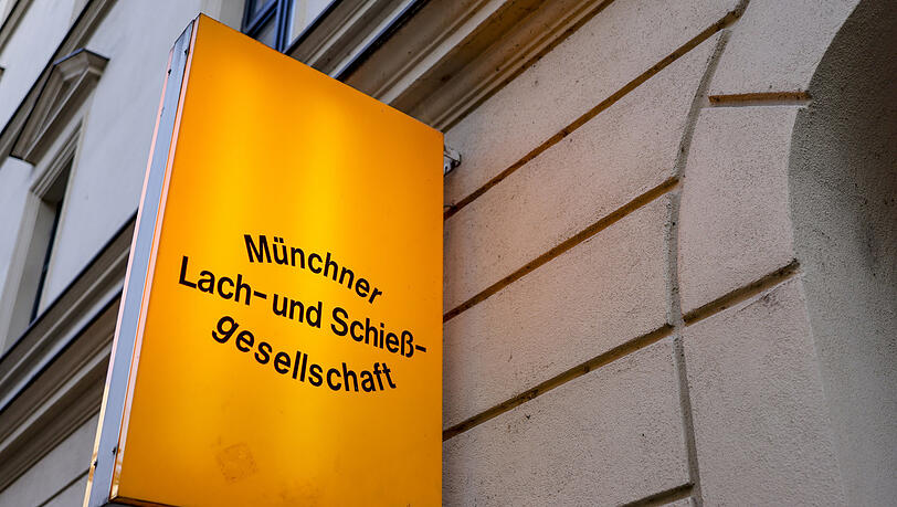 Ein beleuchtetes Schild markiert den Eingang zur Lach- und Schießgesellschaft. Ein beleuchtetes Schild markiert den Eingang zur Lach- und Schießgesellschaft.