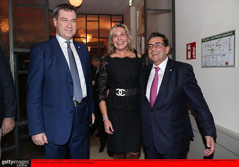 Willkommen beim griechischen Weihnachtsfest: Ministerpräsident Markus Söder (l.) wird von Gastgeber Stavros Kostantinidis und seiner Frau Saskia Greipl-Kostantinidis begrüßt. Der Start eines wunderbaren kurzweiligen Abends.