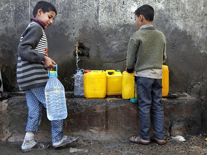 Zwei Jungen holen in Sanaa Wasser an einer Pumpe.