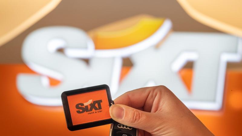 Eine Mitarbeiterin des Autovermieters Sixt hält einen Autoschlüssel in der Hand.