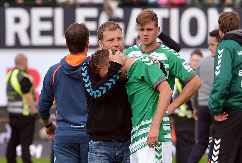 Der Fürther Trainer Frank Kramer (M) muss seine Spieler trösten.