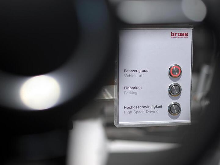 Hinter einem Lenkrad im Showroom des Autozulieferers Brose ist eine Schalttafel aufgestellt. Foto: David-Wolfgang Ebener/dpa/Symbolbild