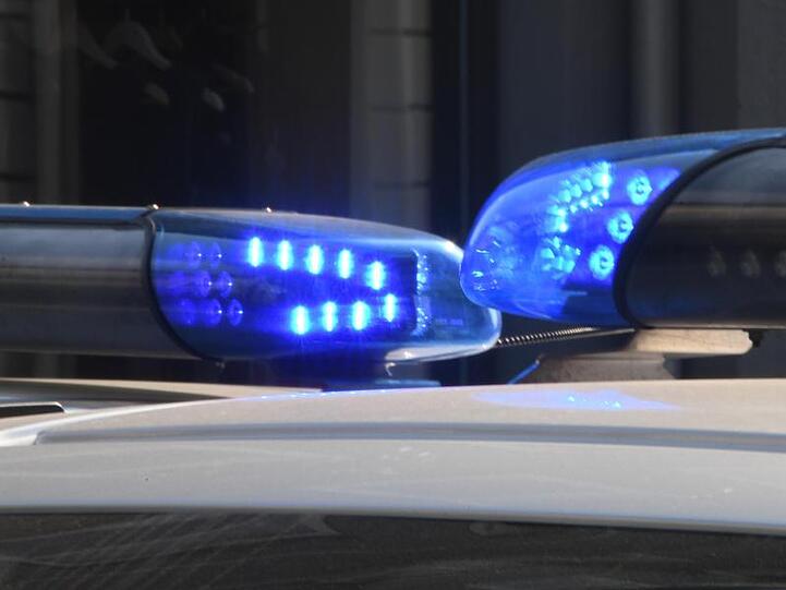 Polizeifahrzeuge stehen mit eingeschaltetem Blaulicht.