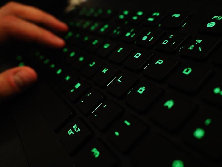 Ein Mann tippt auf einer beleuchteten Tastatur. Foto: Nicolas Armer/Archiv