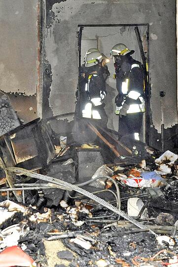 Feuerwehrmänner in der verwüsteten Wohnung.