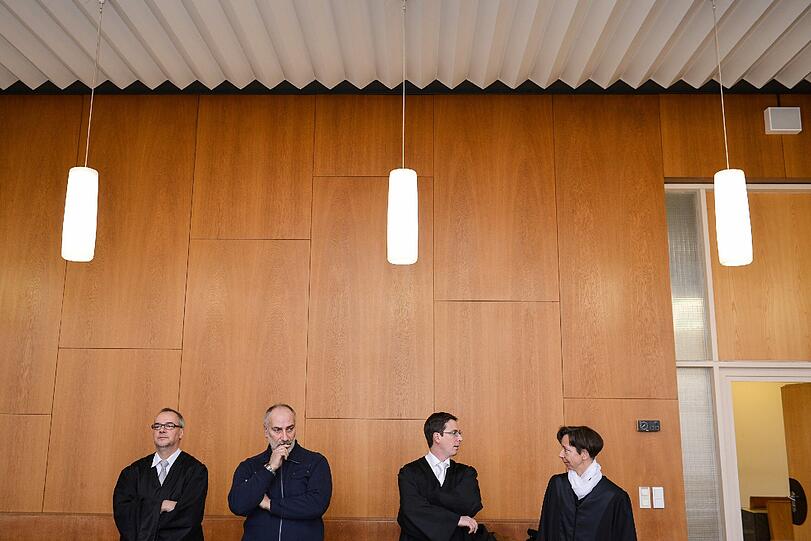 Ein Betreuer (2.v.l) der Angeklagten Kathrin E., sowie deren Strafverteidiger Christoph Jahrsdörfer (l-r) und die Rechtsanwälte Matthias Kolb und Christina Glück unterhalten sich am 20.02.2014 vor Beginn eines Sicherungsverfahrens im Landgericht des Aschaffenburg (Bayern).