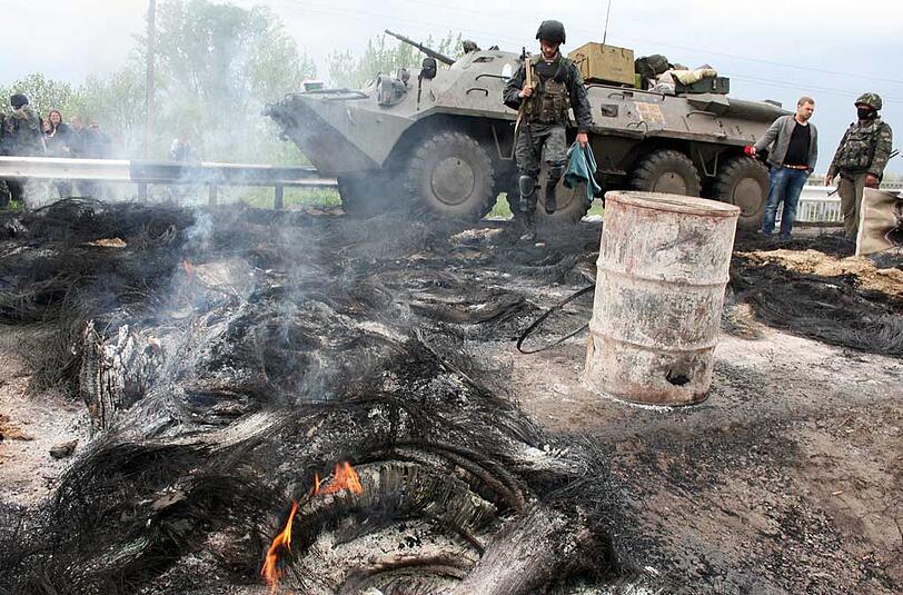 Ein ukrainischer Panzer und ein Soldat stehen in Slawjansk an einer abgebrannten Barrikade prorussischer Separatisten.