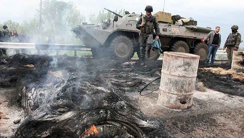 Ein ukrainischer Panzer und ein Soldat stehen in Slawjansk an einer abgebrannten Barrikade prorussischer Separatisten. Ein ukrainischer Panzer und ein Soldat stehen in Slawjansk an einer abgebrannten Barrikade prorussischer Separatisten.