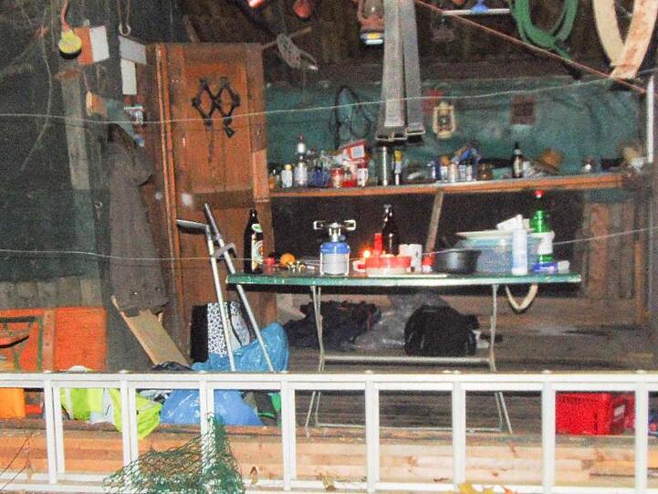 Polizisten stehen in der Holzhütte eines Einsiedlers. Foto: -/Polizeiinspektion Freising /dpa