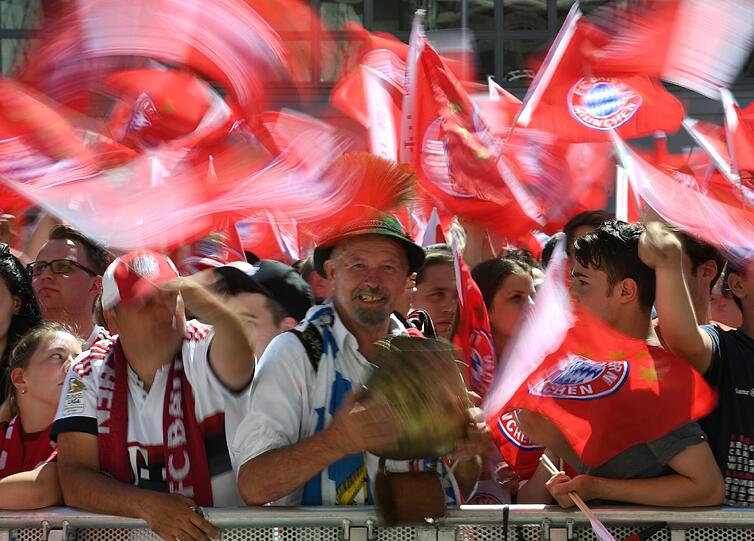 Bei Kaiserwetter warten die Fans am Marienplatz auf ihren FC Bayern.