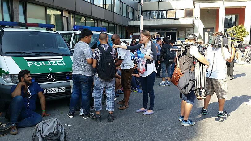 Völlig erschöpft rasten die Flüchtlinge auf dem Bahnhofsvorplatz an der Arnulfstraße und warten auf ihre Registrierung.
