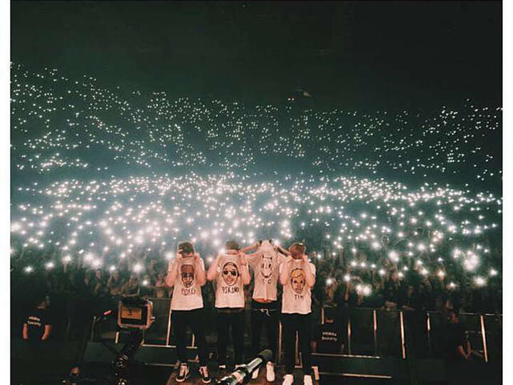 Cro (2. v. r.) und seine Band posieren vor einem leuchtenden Publikum in der Olympiahalle in München