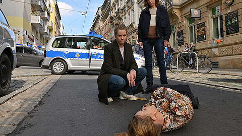 Anna Schneider (Milena Tscharntke) ist auf offener Straße tot zusammengebrochen, daneben Leo Winkler (Cornelia Gröschel, li.) und Karin Gorniak (Karin Hanczewski).