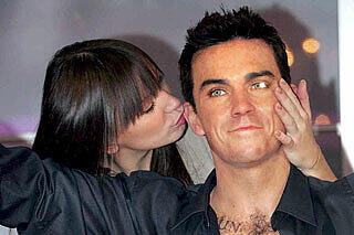 Selbst die Wachs-Version von Robbie Williams kann sich vor Verehrerinnen kaum retten.