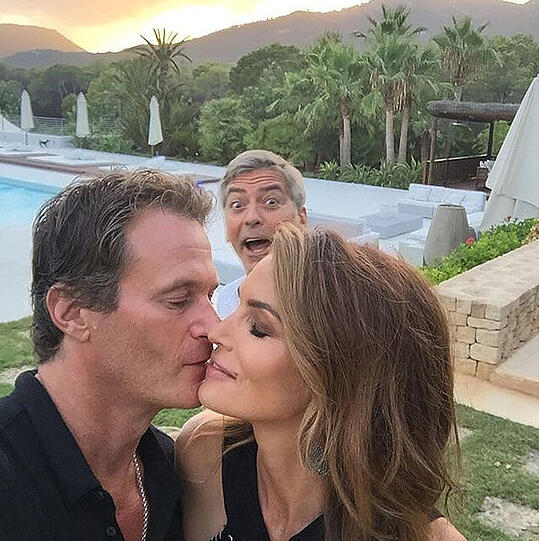 &bdquo;Photo bomber&ldquo;, schreibt Cindy Crawford zum Kuss-Selfie mit Mann Rande Gerber. Gemeint ist der berühmte Kerl hinter ihnen: George Clooney.