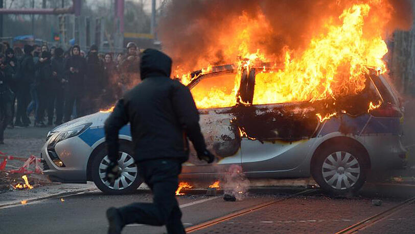 Vermummte Demonstranten haben 2015 vor der Eröffnung der neuen EZB-Zentrale in Frankfurt einen Polizeiwagen angezündet. Angriffe auf Einsatzkräfte sollen künftig strenger bestraft werden. Vermummte Demonstranten haben 2015 vor der Eröffnung der neuen EZB-Zentrale in Frankfurt einen Polizeiwagen angezündet. Angriffe auf Einsatzkräfte sollen künftig strenger bestraft werden.