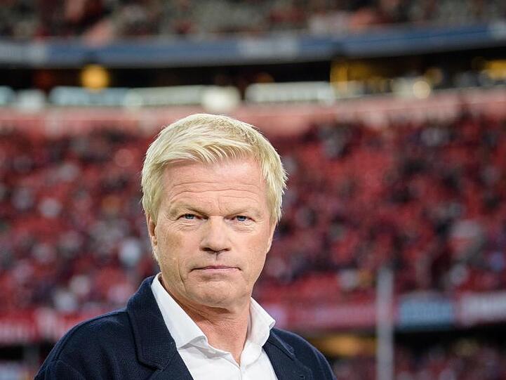 Oliver Kahn hält, am Spielfeldrand stehend, ein Mikrofon in der Hand und schaut in die Kamera. Foto: Matthias Balk/Archiv