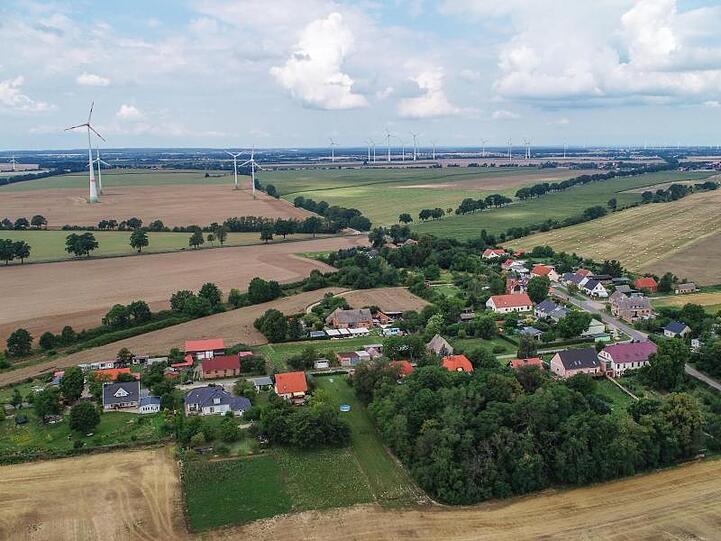 Blick auf das Dorf Carzig mit vielen Windenergieanlagen im Hintergrund. Die geplante Regelung für den Abstand von Windrädern und Wohnsiedlungen sorgt für Ärger.