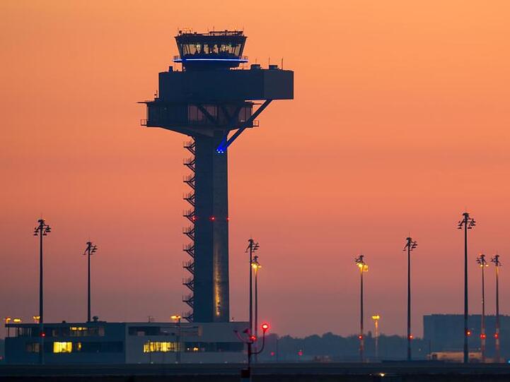 Farbenprächtig leuchtet der Morgenhimmel über dem Gelände des neuen Hauptstadtflughafens Berlin Brandenburg Airport Willy Brandt (BER).