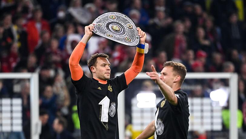 Manuel Neuer (l) und Joshua Kimmich vom FC Bayern München feiern die zehnte Meisterschaft ihres Vereins in Folge.