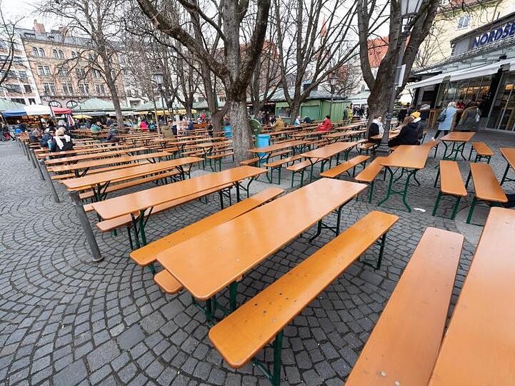 Der um die Mittagszeit ansonsten gut besuchte Biergarten auf dem Viktualienmarkt in München. Foto: Peter Kneffel/dpa
