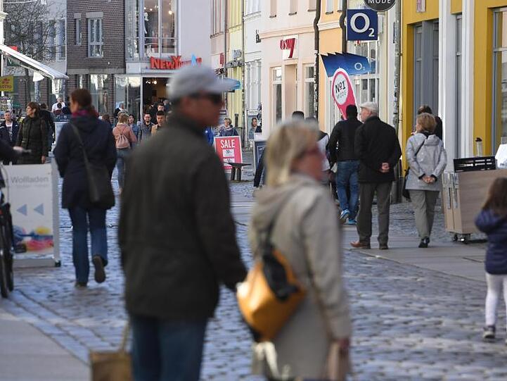 Menschen in einer Einkaufstraße im Zentrum von Stralsund in Mecklenburg-Vorpommern.