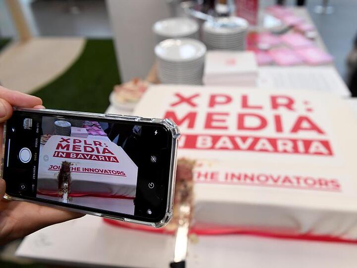In der Messe München ist Kuchen mit einem Logo mit der Aufschrift "XPLR: Media in Bavaria" zu sehen. Foto: Felix Hörhager/dpa/Archivbild