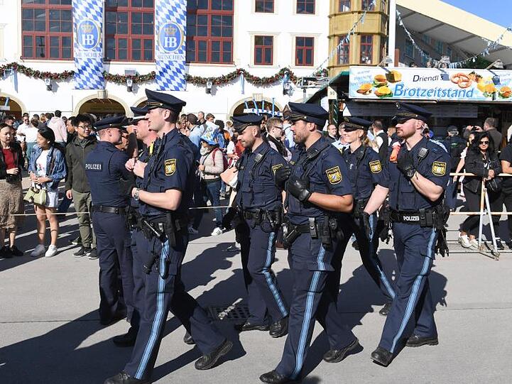 Polizisten gehen über die Festwiese am Oktoberfest. Foto: Felix Hörhager
