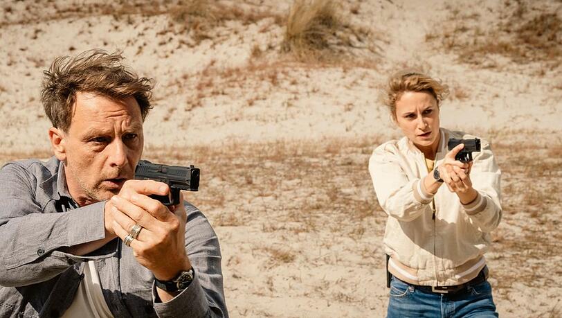 "Dünentod - Ein Nordsee-Krimi: Tod auf dem Meer": Tjark Wold (Hendrik Duryn) und Femke Folkmer (Pia Barucki) ziehen ihre Waffen. "Dünentod - Ein Nordsee-Krimi: Tod auf dem Meer": Tjark Wold (Hendrik Duryn) und Femke Folkmer (Pia Barucki) ziehen ihre Waffen.