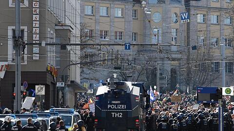 Einsatzkräfte der Polizei stehen bei einer Kundgebung unter dem Motto "Freie Bürger Kassel - Grundrechte und Demokratie" neben einem Wasserwerfer.
