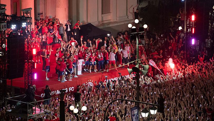 Die Spieler von Olympiakos Piräus feiern mit ihren Fans den Sieg im Conference-League-Finale.